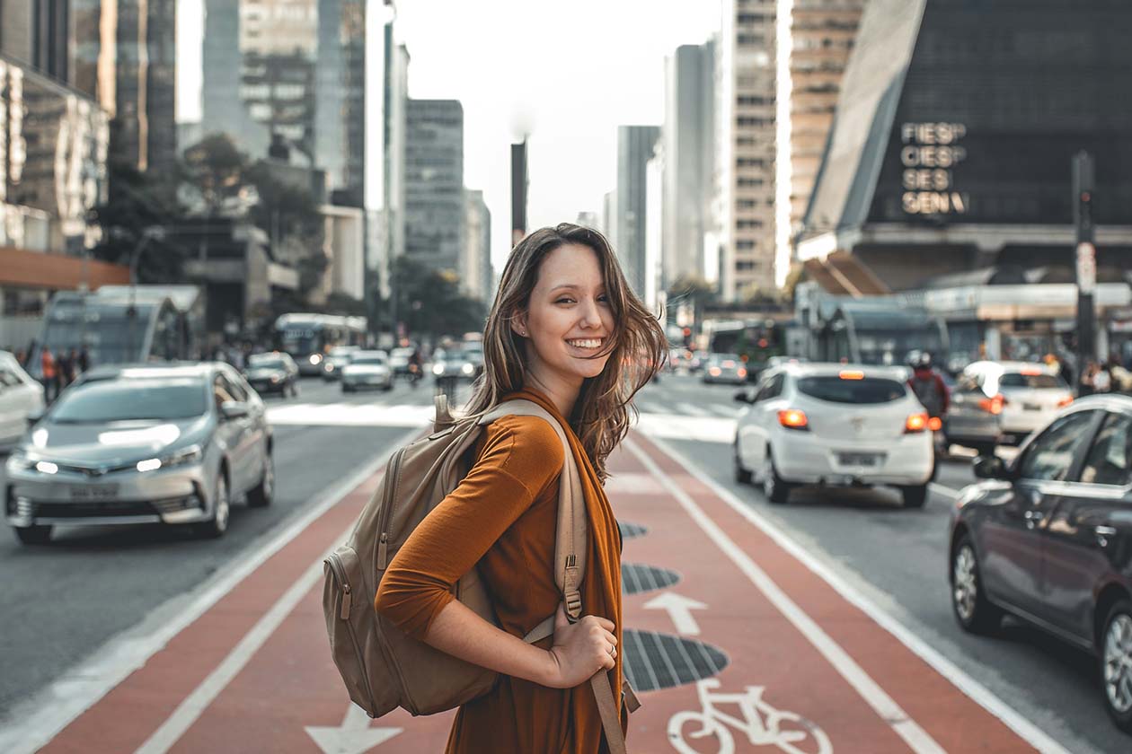 a woman standing in the middle of a busy highway as she looks back while smiling