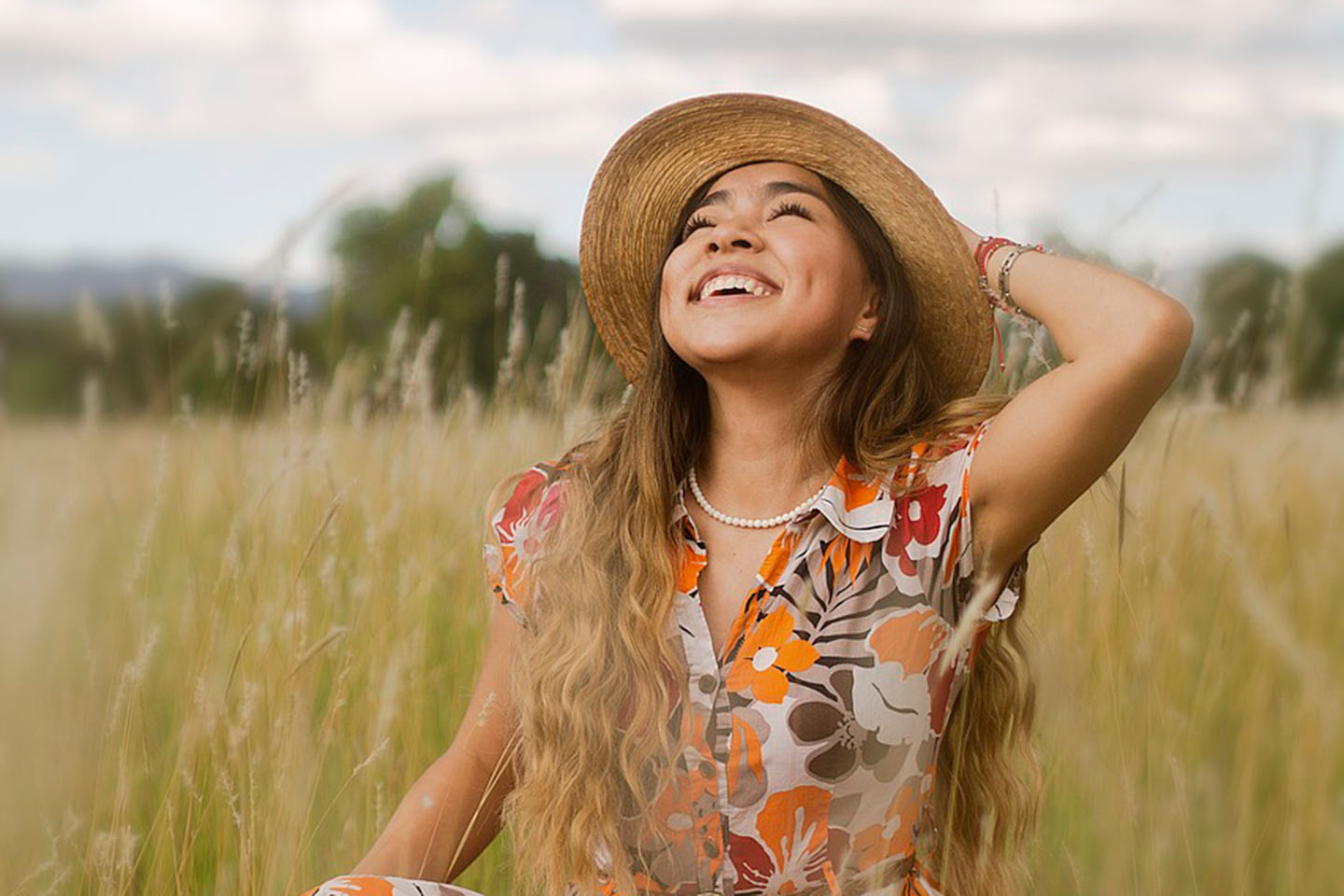 happy girl in flower dress standing in a field
