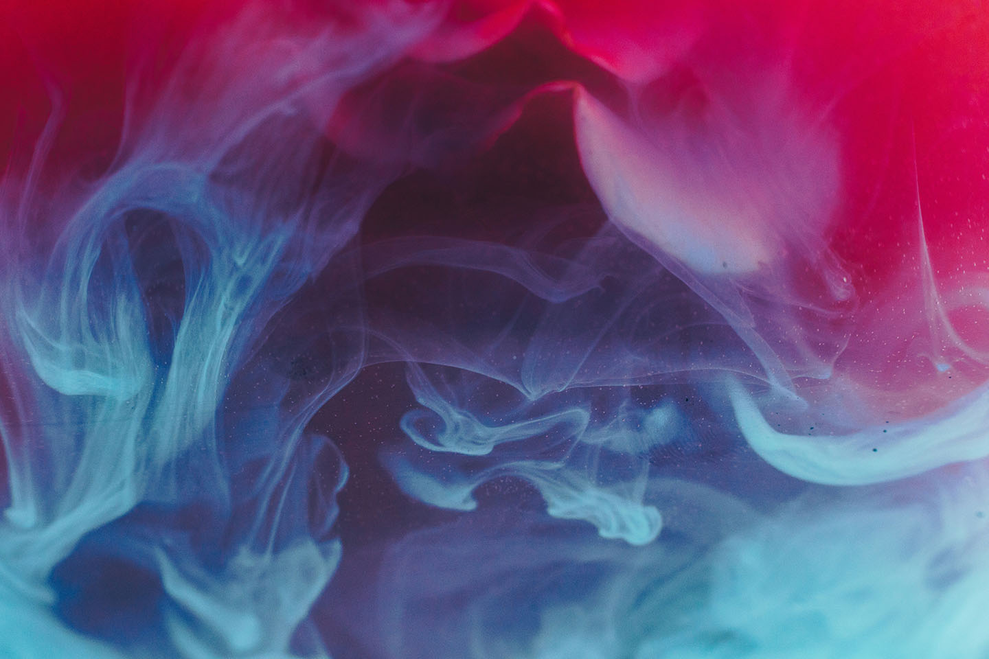 Pink, red, purple, and blue vape clouds mix together.