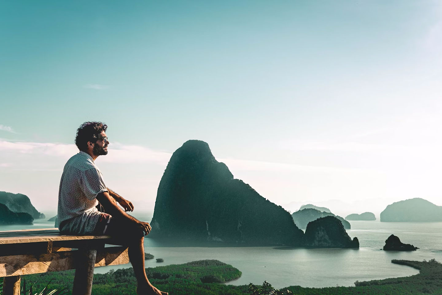 Man sitting on pier at ocean