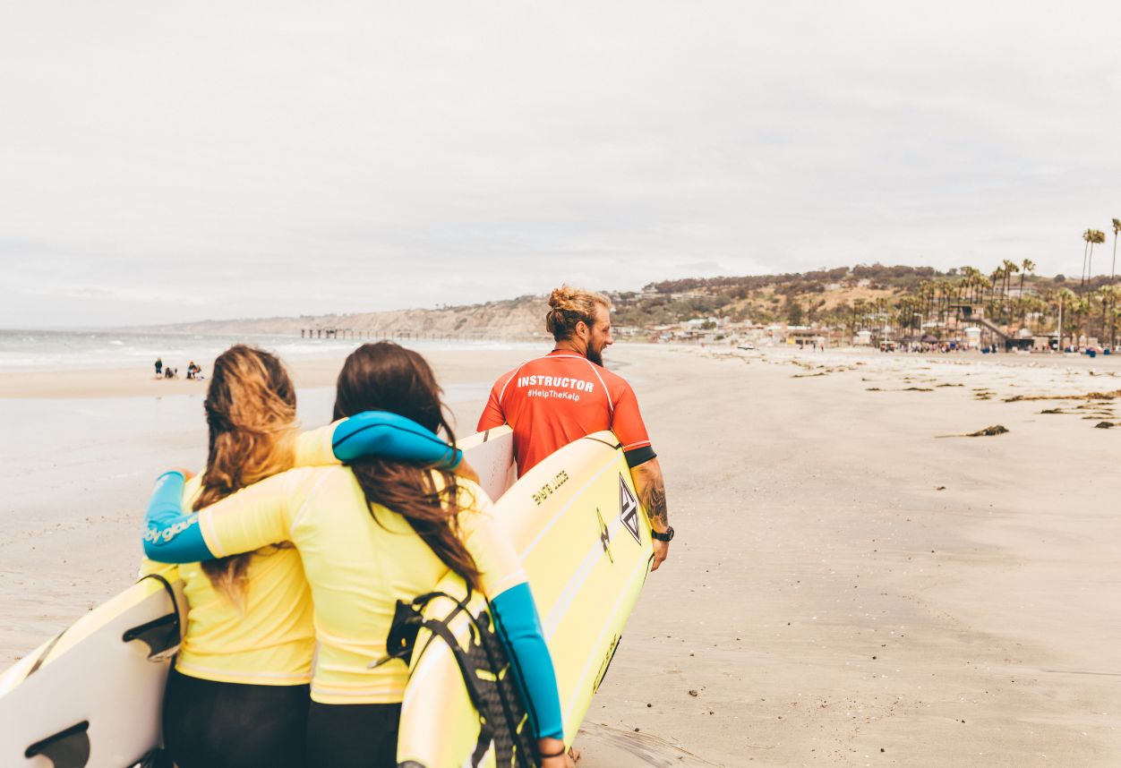 Una pareja a punto de recibir una clase privada de surf para principiantes con Everyday California