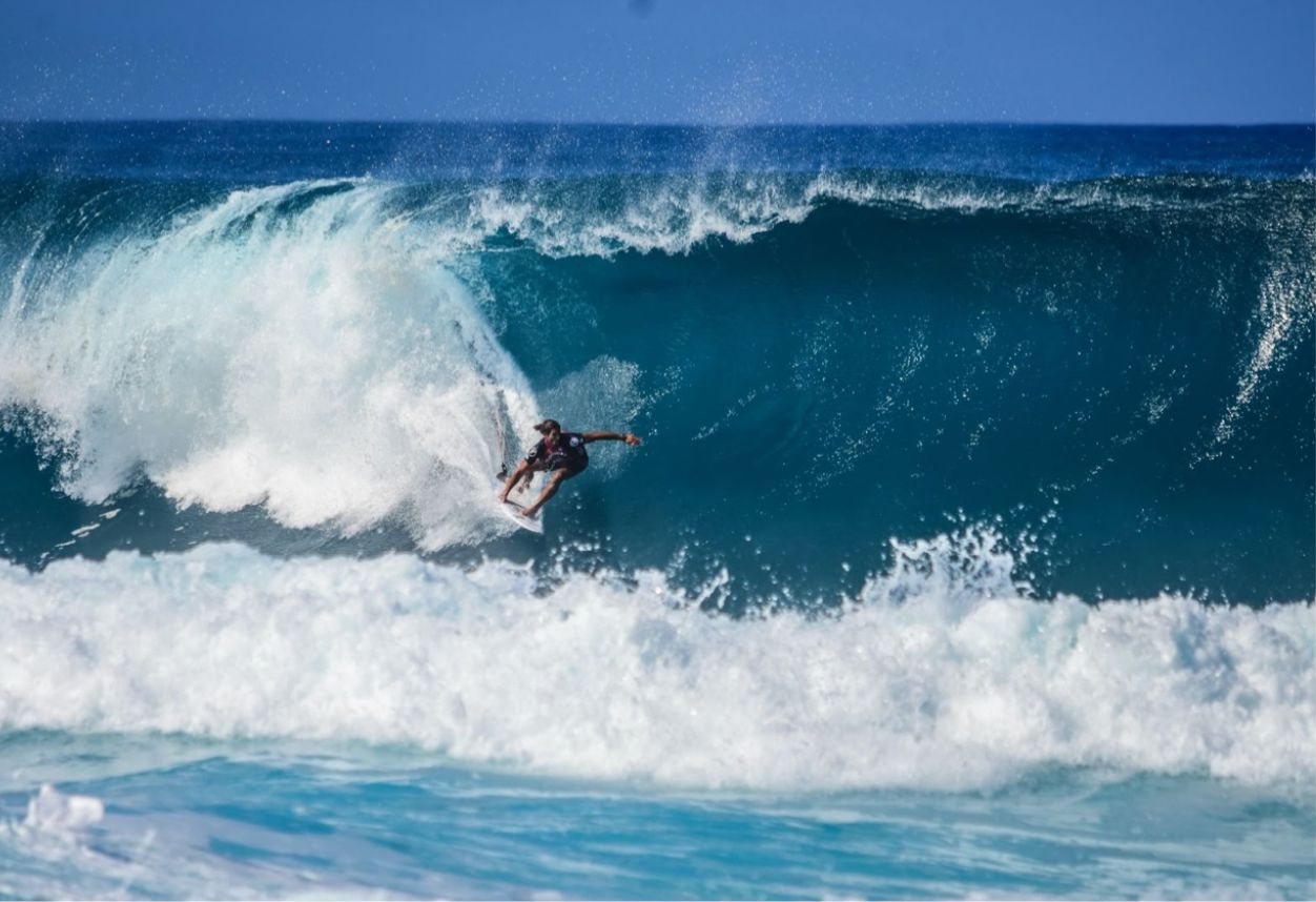 Surfer riding a very large wave. Big wave about to break over the top of him.