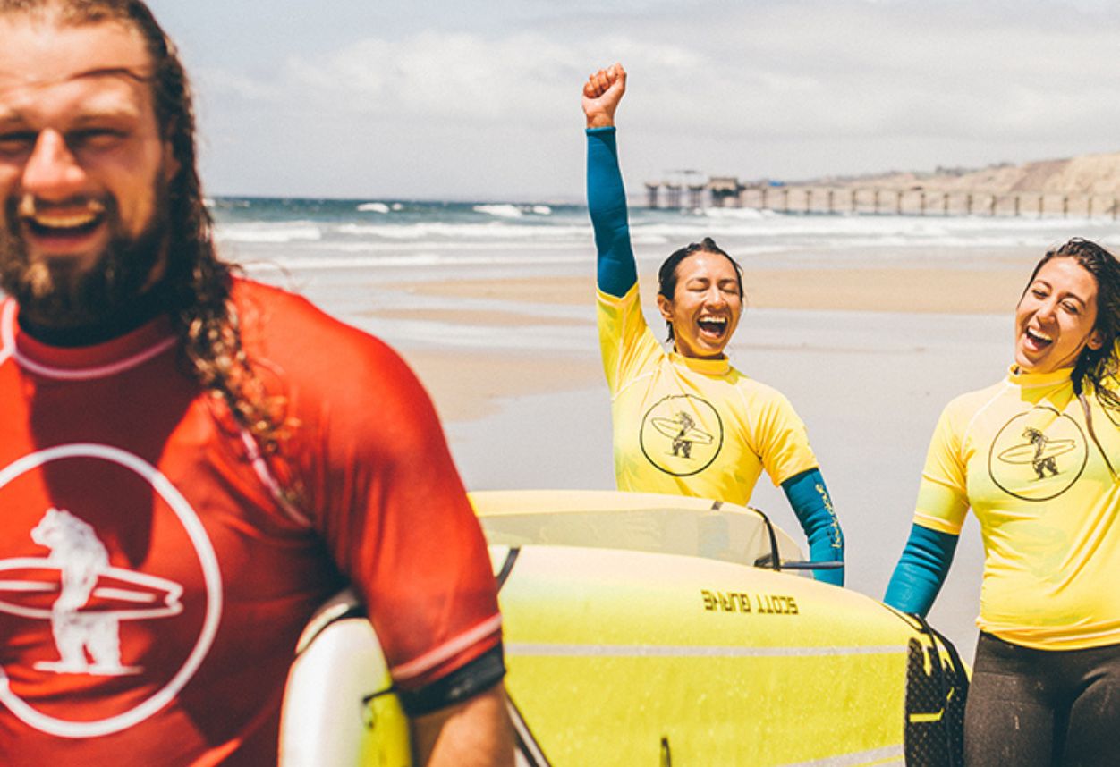 Dos personas emocionadas de ir a su clase de surf en San Diego, California