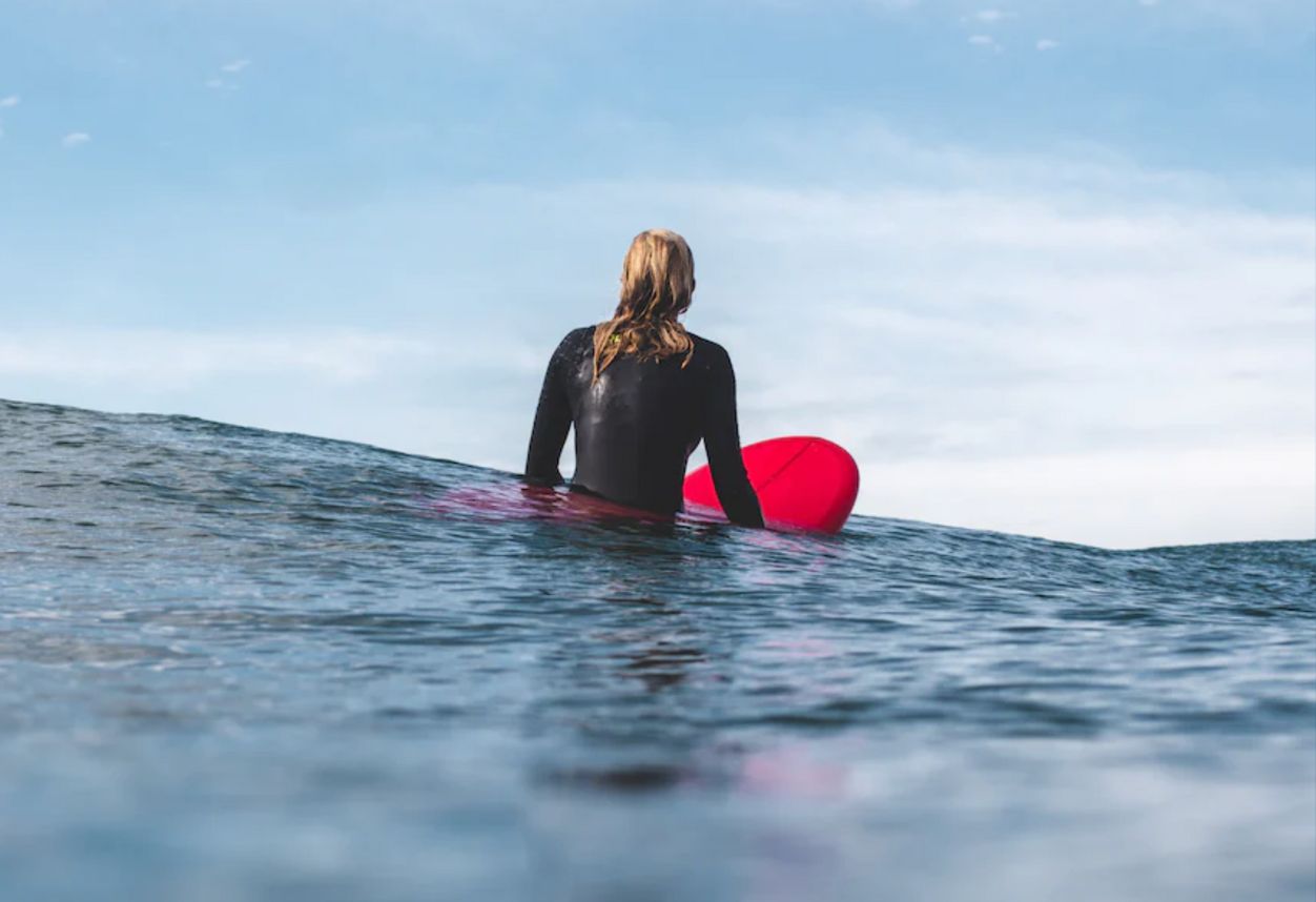 a girl sitting on a surfboard out in the water in San Diego