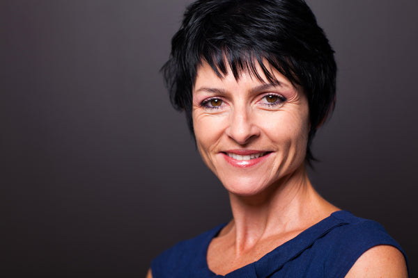 Woman in her late 50's or early 60's with short dyed black hair