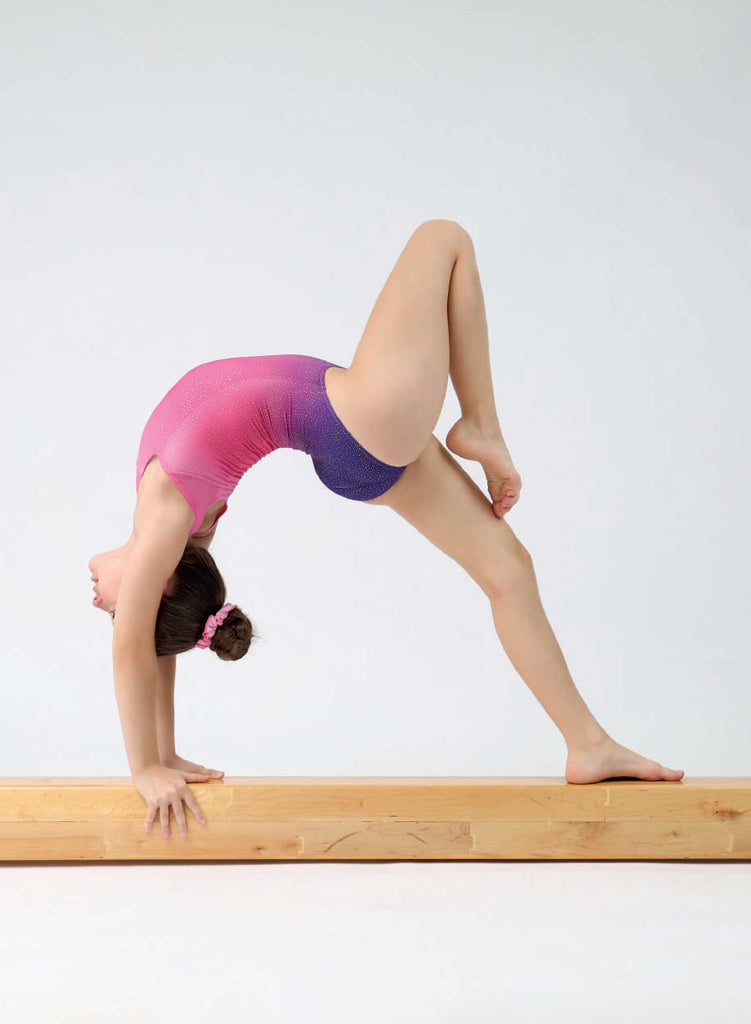 Girl doing gymnastics on a bean in leotard