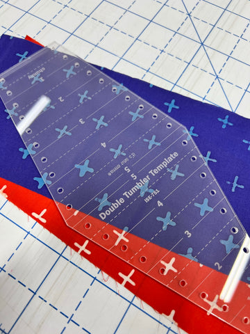 Red and Blue Fabric with a Tumbler Ruler on top.