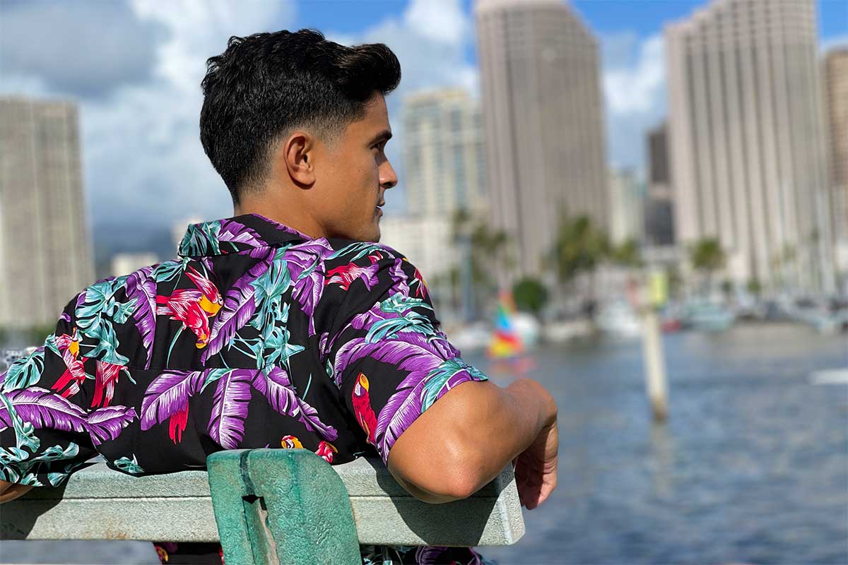 relaxing on park bench in Jungle Bird black Hawaiian shirt