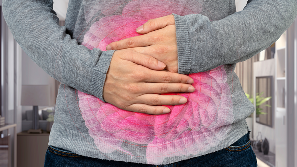 Woman's hands holding stomach in pain