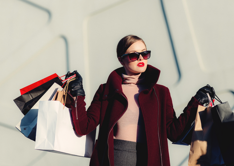 glamorous woman holding many shopping bags