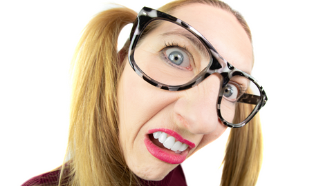 woman's face wearing glasses with a funny disgusted look on her face
