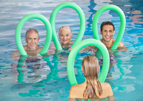 people in a pool holding pool noodles around their heads