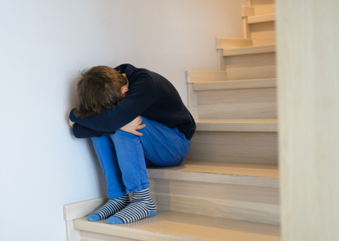 Sad child sitting on stairs