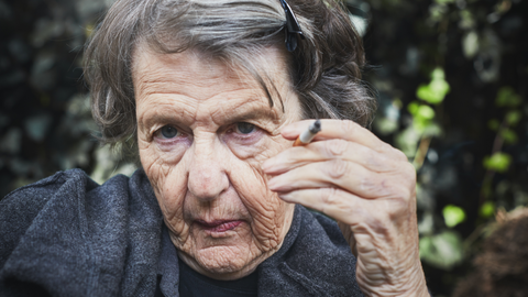 woman in her 60's holding a cigarette