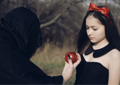 Witch offering young girl and apple