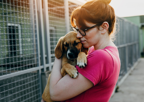 woman holding puppy lovingly
