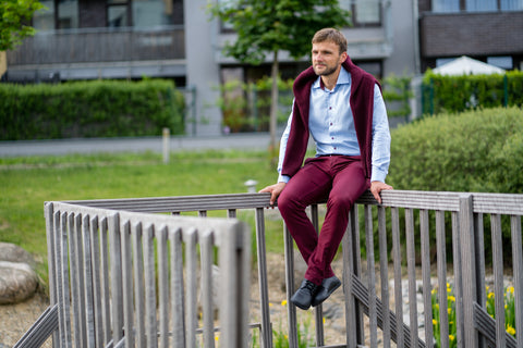 A man in barefoot shoes sitting on a fence