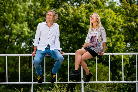 woman and man sitting on a railing wearing Ahinsa barefoot shoes