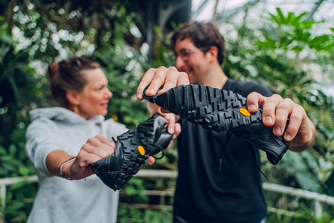 woman and man holding trekking barefoot sneakers Ahinsa shoes