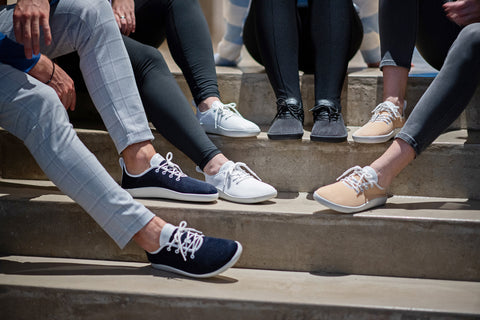 Friends sitting on stairs, all wearing Flow mesh sneakers in various colors