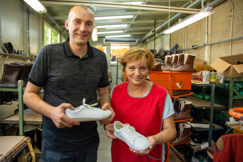 Unsere Kollegen Goran und Štefica halten jeweils einen weißen Pura-Sneaker in der Hand.