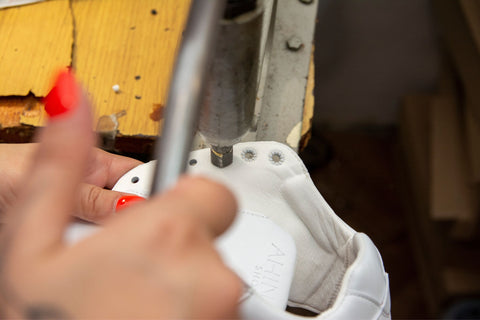 Close-up of the machine that stamps the eyelets into the hole.