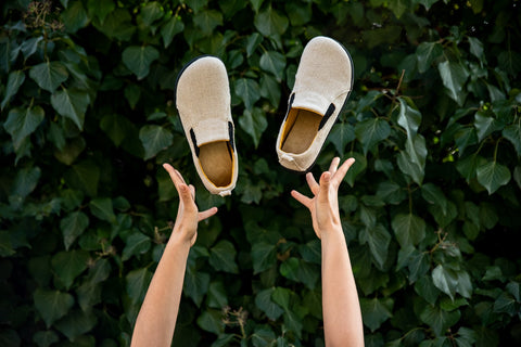 woman throwing Ahinsa hemp slip-on sneakers into the air