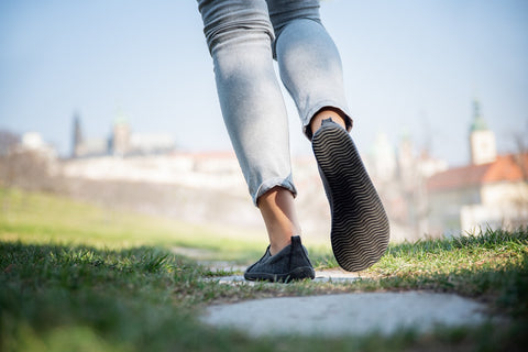 Eine Frau hebt ihren Fuß, Blick auf die Barfußsohle des Ahinsa-Schuhs