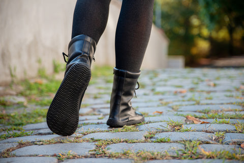 A woman runs through the city in Ahinsa barefoot shoes