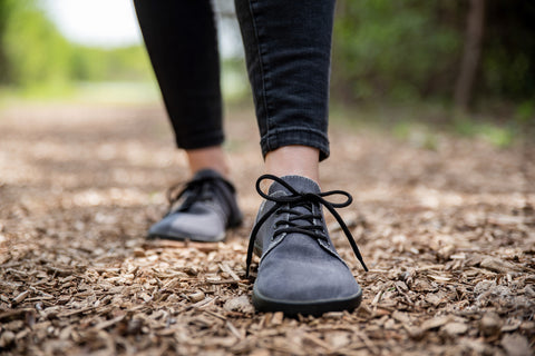 A woman walking on a nature trail in barefoot Ahinsa shoes.