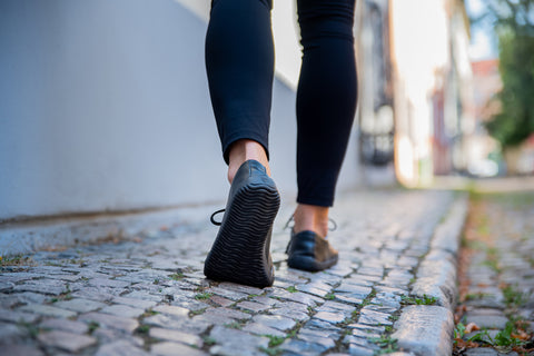 a woman walking through the city in barefoot shoes