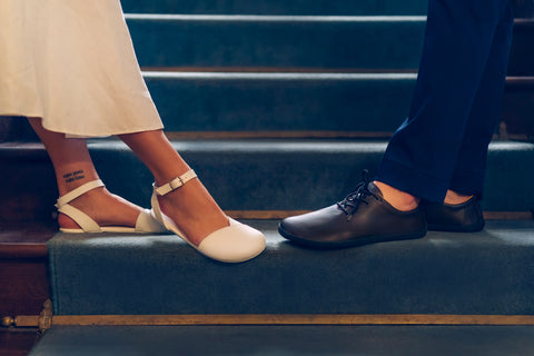 a man in a suit and a woman in a dress, both wearing barefoot Ahinsa shoes