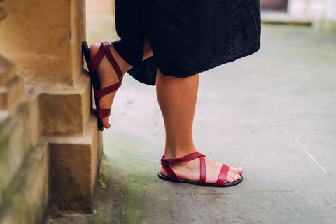Eine Frau in roten Ahinsa-Sandalen mit Riemen