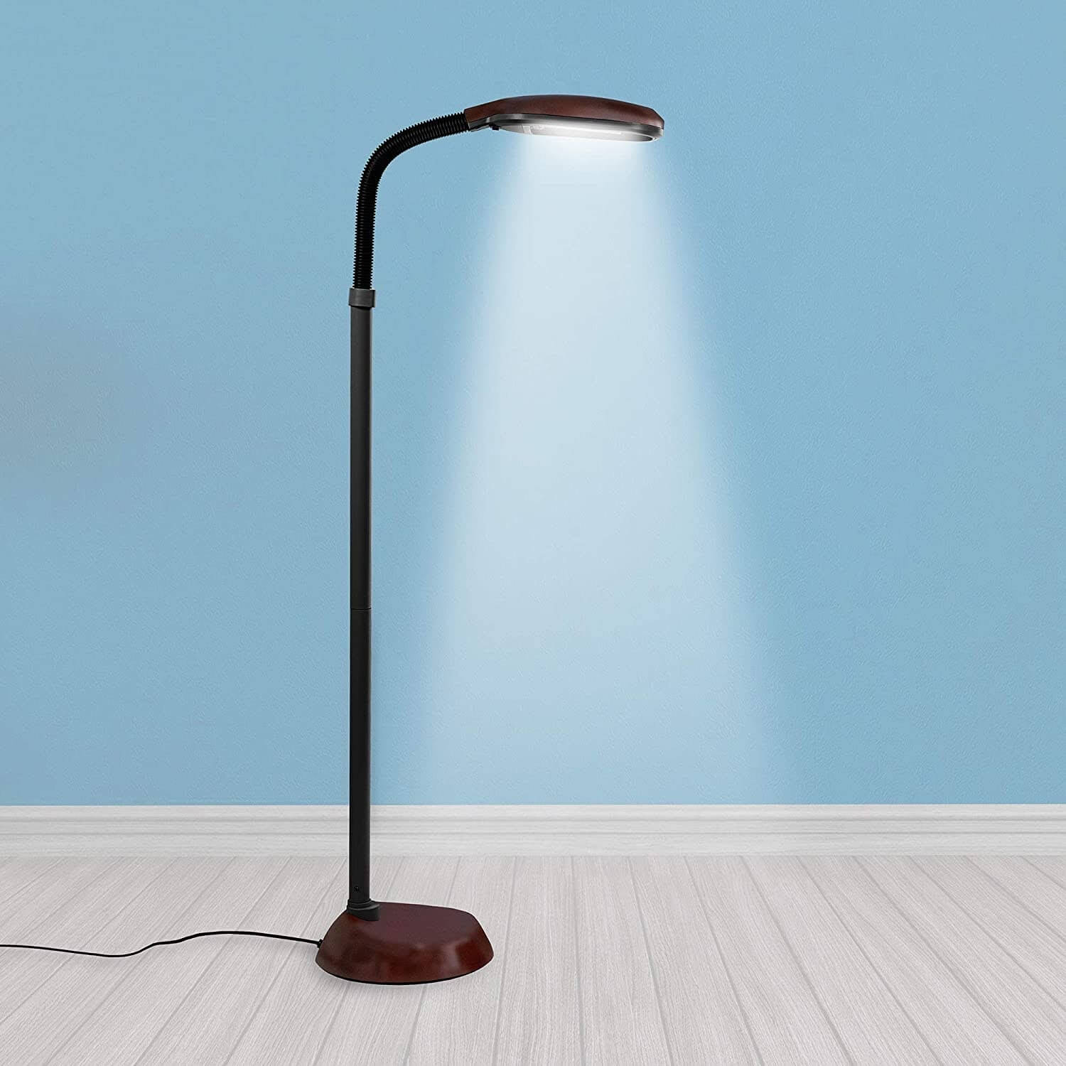 A brightly lit lamp standing on a wooden surface.