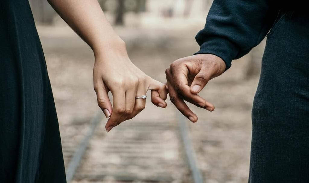 A pinky finger of two people in a pinky swear.