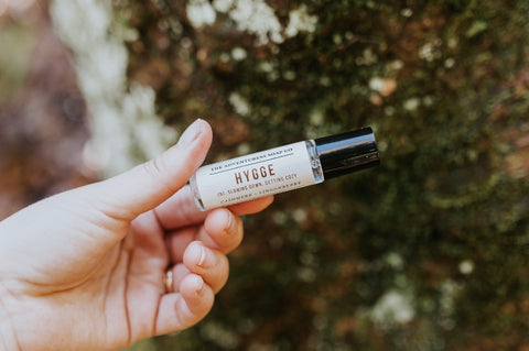 hygge perfume, hygge inspired perfume being held in forest