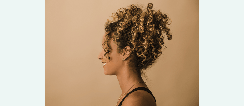 woman with curly hair uses brahmi for hair growth