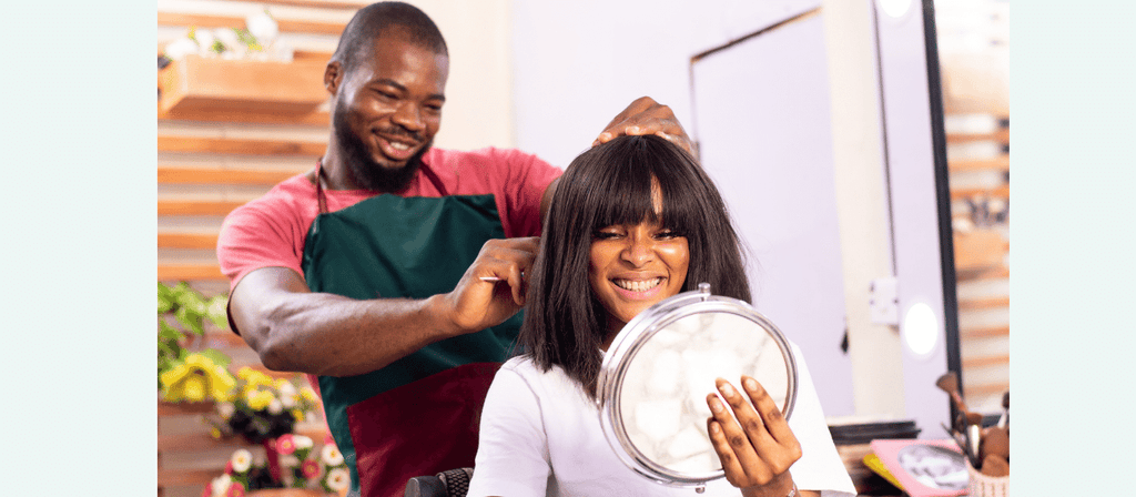 woman gets hair trimmed at salon