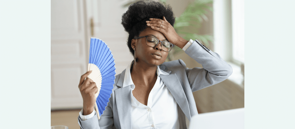 black woman uses fan to prevent frizzy natural hair