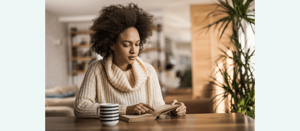 black woman reads about hair care ingredients for curly hair