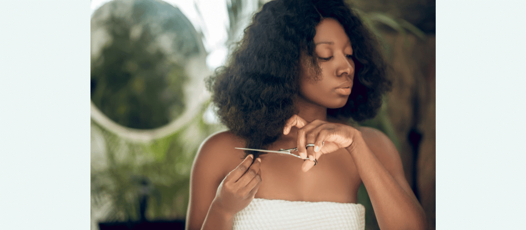 black woman trims hair