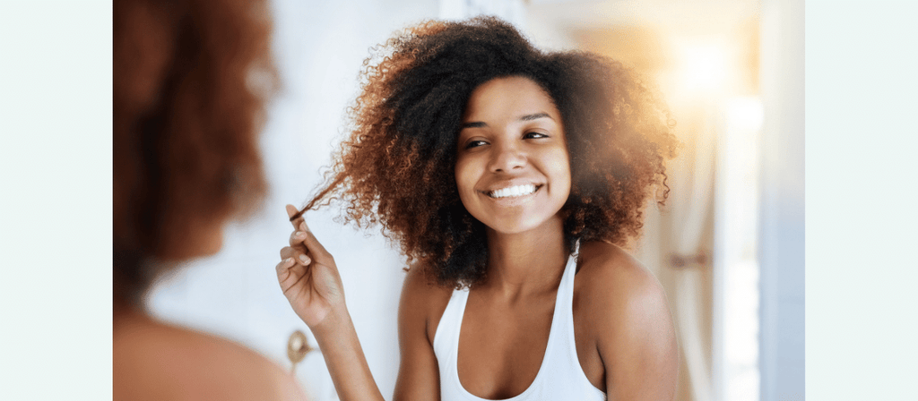 black woman uses organic hair care products for curly hair