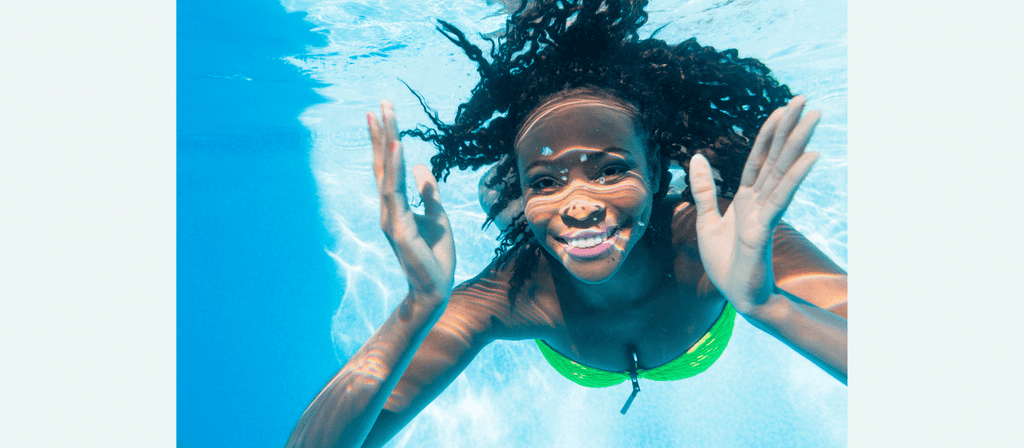 black woman in pool with healthy afro hair