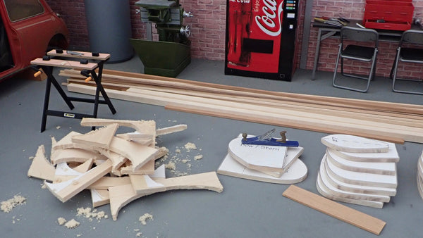 A scale model strongback for canoe building with canoe molds beside it