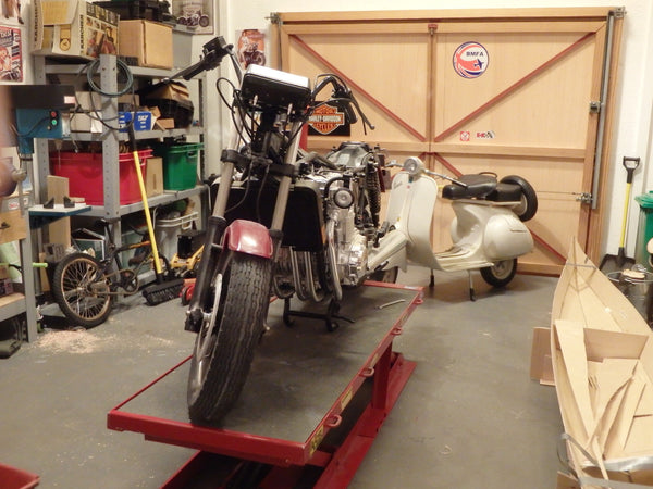 A scale model motorcycle sits in a diorama garage