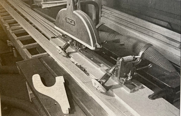 Photo shows anti-kickback jig in use, holding a plank down on a table saw
