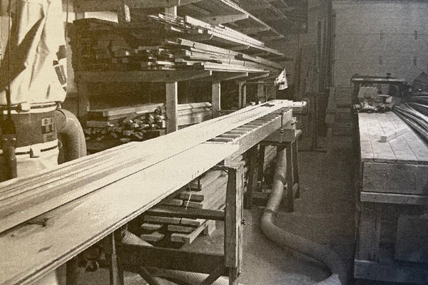 Long, level low-friction surface set up in a woodshop as outfeed for cutting planking