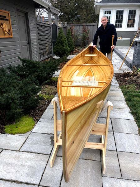 Photo looking down the bow of a Nomad 17 canoe while the builder stands at the stern