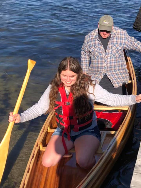 William John Beyette and granddaughter Zara get into their newly built Bob's Special canoe beside a dock