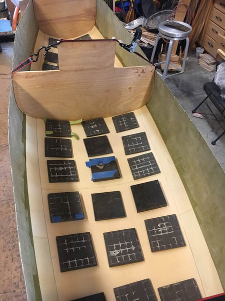 Foam pads are laid out in the bottom of a canoe as part of the process of strengthening the hull